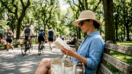 Woman sitting on park bench wearing sun hat