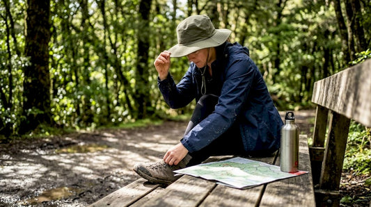 Woman adjusting hiking hat on forest trail