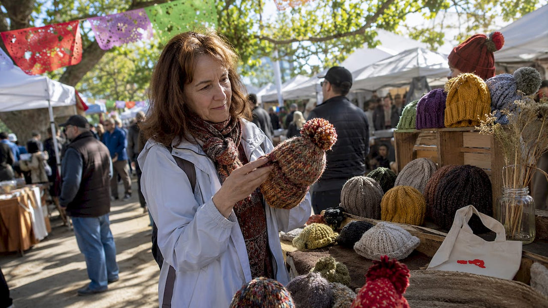 Woman examining wool hat at outdoor eco market