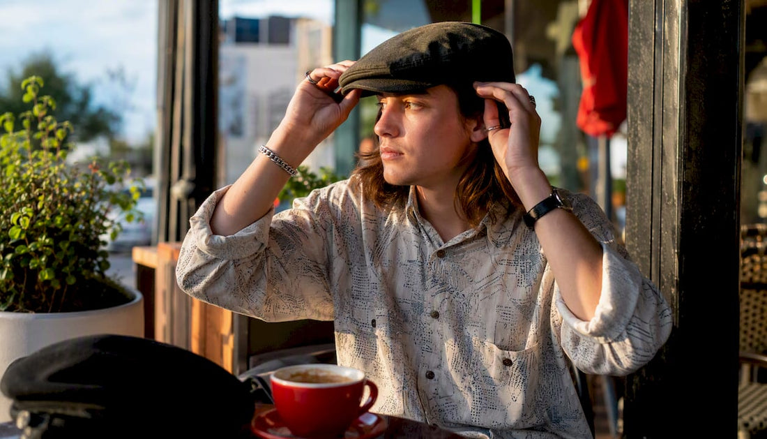 Person wearing fedora adjusting hat in park