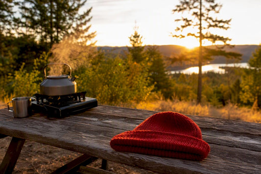 Hands steaming wool hat near kettle