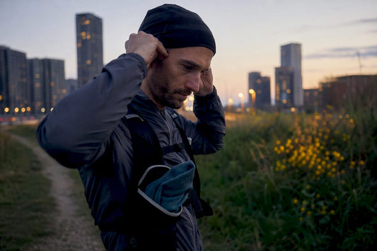 Runner adjusting beanie on early morning trail