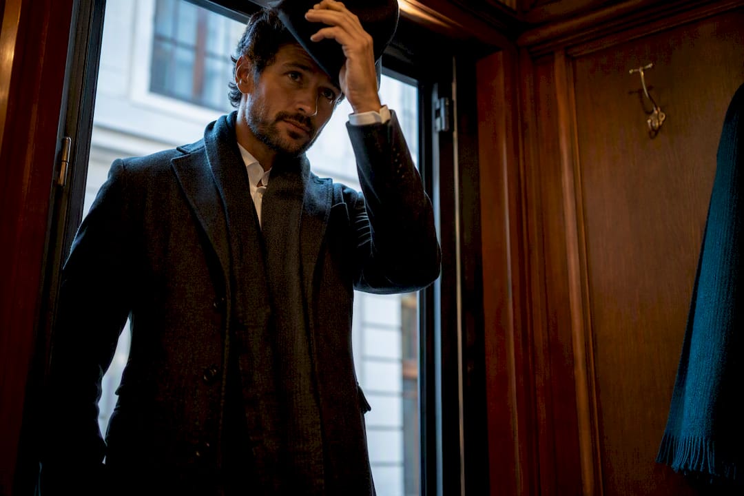 Man removing hat at indoor doorway