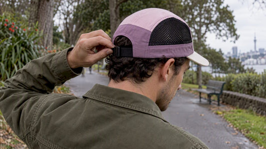 Wearer adjusting a five-panel cap closure