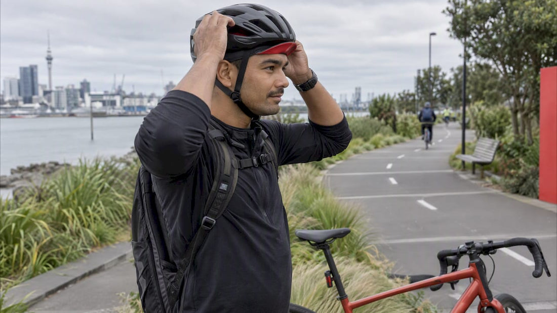 Cyclist fitting a helmet over a lightweight cap